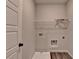 Functional laundry room with utility sink, storage shelf, and modern wood-look flooring at 1620 Branthaven Ln, Auburn, GA 30011