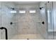 Modern glass shower with dual showerheads, bench seating, and marble-patterned tile at 1620 Branthaven Ln, Auburn, GA 30011