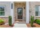 Welcoming front door with brick accents, manicured bushes, and a 