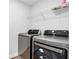 Modern laundry room features stainless steel washer and dryer and a wire shelf for storage at 1768 Evenstad Way, Smyrna, GA 30080