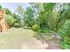 Backyard with trees, lawn, and a set of wooden stairs leading to a large upper deck at 2041 Democracy Dr, Buford, GA 30519