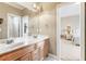 Bright bathroom featuring double sink vanity with warm lighting, open to bedroom and shower room at 2041 Democracy Dr, Buford, GA 30519