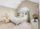 Bright bedroom featuring a vaulted ceiling, arched window, and neutral decor at 2041 Democracy Dr, Buford, GA 30519