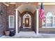 Inviting front entrance with stone columns, a decorative wooden door, and an American flag at 2041 Democracy Dr, Buford, GA 30519