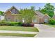 Inviting home with stone details, a manicured lawn, and established landscaping at 2041 Democracy Dr, Buford, GA 30519