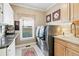 Well-lit laundry room with modern washer and dryer, storage cabinets, and tiled floors at 2041 Democracy Dr, Buford, GA 30519