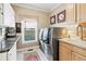 Well-lit laundry room features granite countertops, upper and lower cabinets, and stainless steel washer and dryer at 2041 Democracy Dr, Buford, GA 30519