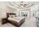 Luxurious primary bedroom featuring a tray ceiling, cozy seating area, and elegant decor at 2041 Democracy Dr, Buford, GA 30519