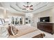 Primary bedroom with tray ceiling, large windows, and decorative bed furnishings at 2041 Democracy Dr, Buford, GA 30519