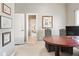 Home office with a view into the hallway featuring a desk, upholstered chairs, and stylish wall décor at 2041 Democracy Dr, Buford, GA 30519