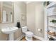 Cozy powder room featuring pedestal sink, decorative mirror, and shelving with decorative items at 2041 Democracy Dr, Buford, GA 30519