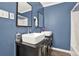 Bathroom vanity with double sinks, framed mirrors, and blue walls at 232 S Candler St, Villa Rica, GA 30180