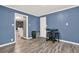 Dining area with blue walls and tile flooring with a doorway leading to a living area at 232 S Candler St, Villa Rica, GA 30180