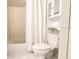 Bright bathroom featuring a shower/tub combo, toilet, and storage cabinet at 310 Hillpine Dr, Woodstock, GA 30189