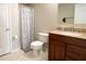 Traditional bathroom with a wood vanity, granite countertop, toilet, and a shower with patterned curtain at 310 Hillpine Dr, Woodstock, GA 30189