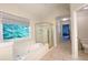 Bathroom featuring a garden tub and shower with natural lighting, view of water closet and hall at 310 Hillpine Dr, Woodstock, GA 30189