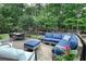 Inviting deck area featuring comfortable blue seating, a coffee table, and views of the wooded backyard at 310 Hillpine Dr, Woodstock, GA 30189