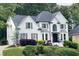 Beautiful white home with grey shutters, a well-maintained lawn, and an attached garage, offering ample space at 310 Hillpine Dr, Woodstock, GA 30189