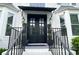 Elegant double front doors with a stylish black awning and decorative potted plants, creating a welcoming entrance at 310 Hillpine Dr, Woodstock, GA 30189