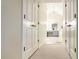 Hallway view showing closets leading to a bathroom with vanity and plenty of light at 310 Hillpine Dr, Woodstock, GA 30189