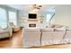 Bright living room features fireplace, mounted TV, ceiling fan and hardwood floors at 310 Hillpine Dr, Woodstock, GA 30189