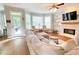 Well-lit living room with fireplace, TV, hardwood floors and convenient access to a patio at 310 Hillpine Dr, Woodstock, GA 30189