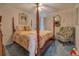 Traditional bedroom with a four-poster bed, cozy armchair, and classic decor at 3870 Michaels Creek Ct, Loganville, GA 30052