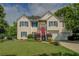 Charming two-story home with a well-manicured lawn and a pop of color from the red front door at 3870 Michaels Creek Ct, Loganville, GA 30052