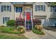 Inviting front entrance with a red door, blue stairs, and a beautiful landscaped garden at 3870 Michaels Creek Ct, Loganville, GA 30052