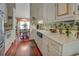 Bright kitchen leading to dining area, featuring white cabinets and hardwood floors at 3870 Michaels Creek Ct, Loganville, GA 30052