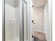 Bathroom with a white shower and glass door, next to a hallway with carpeted floors and freshly painted walls at 540 Windermere Dr, Loganville, GA 30052