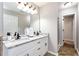Main bathroom features double vanity with stone countertop and framed mirror at 540 Windermere Dr, Loganville, GA 30052