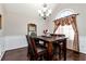 Formal dining room with wainscoting, hardwood floors, elegant lighting, and a large window at 540 Windermere Dr, Loganville, GA 30052