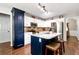 Bright kitchen features white cabinets, granite countertops, stainless steel appliances, and island with bar stool seating at 540 Windermere Dr, Loganville, GA 30052