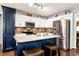 Modern kitchen with granite countertops, stainless steel appliances, and a blue kitchen island with seating at 540 Windermere Dr, Loganville, GA 30052