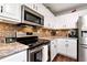 Well-lit kitchen featuring modern appliances, granite countertops, and ample cabinet space at 540 Windermere Dr, Loganville, GA 30052