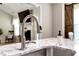 Close-up of a kitchen faucet with living room in the background, barn door is visible at 540 Windermere Dr, Loganville, GA 30052