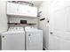 Laundry room features white washer, dryer, storage cabinets and hanging rod at 540 Windermere Dr, Loganville, GA 30052