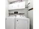 White washer and dryer, white cabinets, and folding shelf in the laundry room at 540 Windermere Dr, Loganville, GA 30052