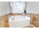 Large tub with tiled surround in the main bathroom at 540 Windermere Dr, Loganville, GA 30052