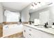 The main bathroom features double sink vanity, soaking tub, and tile flooring at 540 Windermere Dr, Loganville, GA 30052