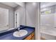 Bathroom featuring blue vanity, sink, and tub at 261 Township Dr, Hiram, GA 30141