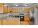 Modern kitchen features granite countertops, stainless steel appliances, and wood cabinets, offering ample storage and prep space at 261 Township Dr, Hiram, GA 30141