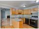 Functional kitchen featuring granite countertops, wooden cabinets, and stainless steel appliances, with an open view to the living room at 261 Township Dr, Hiram, GA 30141