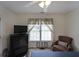 Cozy bedroom featuring a ceiling fan, window with blinds, and comfortable seating at 2892 Motts Cove Holw, Lawrenceville, GA 30043