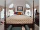 Serene main bedroom featuring a four-poster bed, bright windows, and elegant decor at 2892 Motts Cove Holw, Lawrenceville, GA 30043