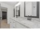 Bright bathroom featuring double sinks, granite countertops, modern fixtures, and a shower with white subway tile at 4045 White Oak Sw Ln, Lilburn, GA 30047