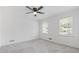 Light-filled bedroom with carpet, ceiling fan, and two windows showcasing natural lighting at 4045 White Oak Sw Ln, Lilburn, GA 30047