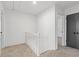 Second-floor hallway with carpet and view to a door and staircase with white railing at 4045 White Oak Sw Ln, Lilburn, GA 30047
