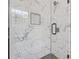 Bright shower featuring updated tile, glass doors, rainfall shower head, and natural light at 4045 White Oak Sw Ln, Lilburn, GA 30047